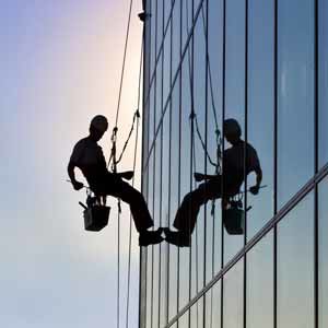 Man repelling doing commercial window cleaning